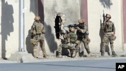 FILE - Afghan security personnel take positions near the Shamshad Television station after a deadly attack in Kabul, Afghanistan, Nov. 7, 2017, for which the Islamic State group claimed responsibility.