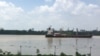 A container ship moves along the Saigon River, used to ship the kinds of exports that have increased Vietnam’s role in global trade.