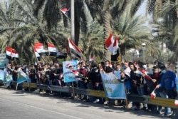 Adeptos de la Iglesia Católica esperan al Papa Francisco en su visita a Irak.