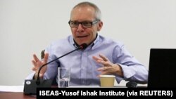 FILE - Sean Turnell discusses economic reforms by Myanmar's NLD government at a seminar in Singapore, May 2018.