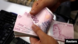 FILE - A money changer counts Turkish lira banknotes at a currency exchange office in Istanbul, Turkey, Aug. 2, 2018. 