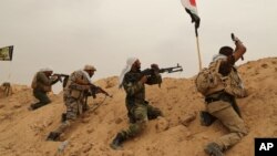 Fighters from Badr Brigades Shiite militia clash with Islamic State group militants at the front line on the outskirts of Fallujah, Anbar province, Iraq, June 1, 2015. 