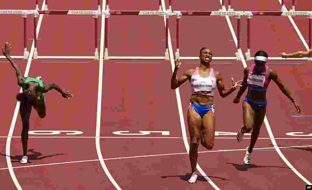 Jasmine Camacho-Quinn, of Puerto Rico, center, celebrates after winning the gold in the women's 100-meters hurdles final ahead of Kendra Harrison, of United States, silver, right, and Tobi Amusan, of Nigeria, fourth, at the 2020 Summer Olympics, Monday, Aug. 2, 2021, in Tokyo, Japan. (AP Photo/Charlie Riedel)
