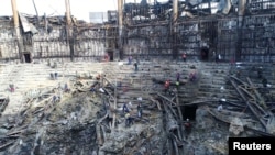 Members of the Russian Emergencies Ministry and workers remove debris inside the burnt-out Crocus City Hall following a deadly attack on the concert venue outside Moscow, in this still image taken from video released March 26, 2024. (Russian Emergencies Ministry/Handout)