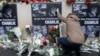 A person places flowers in front of the offices of weekly satirical newspaper Charlie Hebdo in Paris, Jan. 8, 2015.
