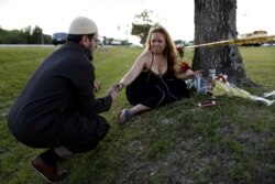 FILE - Daniel Hernandez, a local imam, comforts Dih-Anaa Forero of Missouri City, near the site of the shooting at the Santa Fe High School, in Santa Fe, Texas, May 19, 2018.