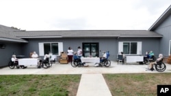 FILE - In this June 25, 2020, photo, residents at the Southern Pines nursing home are separated and wear face coverings during their daily bingo game in Warner Robins, Georgia.