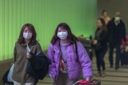 Travelers arrive at LAX Tom Bradley International Terminal wearing medical masks for protection against the novel coronavirus outbreak on February 2, 2020 in Los Angeles, California.