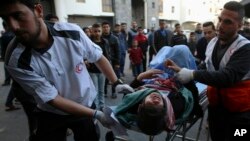 Medics move a wounded youth, who was shot by Israeli troops during a protest at the Gaza Strip's border with Israel, into the treatment room of Shifa hospital in Gaza City, Friday, March 22, 2019.