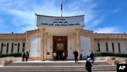 FILE - People walk outside Iraqi Criminal Court in Baghdad's Karkh district, Iraq, May 5, 2019. On Wednesday, a wife of deceased Islamic State leader Abu Bakr al-Baghdadi was sentenced to death for allegedly helping detain Yazidi women.  