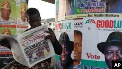 Nigerian man read a local newspapers with headlines, Independent National Electoral Commission flops, over a Portrait of Nigeria President Goodluck Jonathan in Lagos, April 3, 2011
