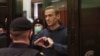 Alexei Navalny, pemimpin oposisi Rusia, menunjukkan simbol hati dalam persidangan di Moskow, Rusia. 