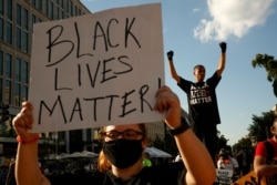 FILE - Antonio Mingo, right, holds his fists in the air as demonstrators protest on a section of 16th Street renamed Black Lives Matter Plaza, in Washington, June 24, 2020. The Black National Convention will be held Aug. 28, 2020.