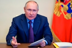 Russian President Vladimir Putin gestures during a meeting via video conference outside Moscow, Russia, April 15, 2021.