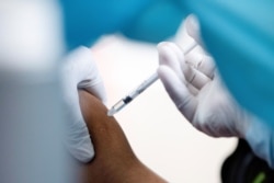 FILE - A medical worker receives AstraZeneca's COVISHIELD coronavirus disease (COVID-19) vaccine in Yangon, Myanmar, Jan. 27, 2021.