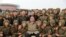 This undated picture released from North Korea's official Korean Central News Agency, Nov. 18, 2019, shows North Korean leader Kim Jong Un posing with members of the Air and Anti-Aircraft Force of the Korean People's Army.