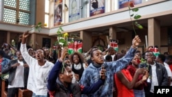 FILE - Youth attending a special dedication service at the Holy Family Basilica hold roses in honor of lives lost during recent protests against government-proposed tax hikes, in Nairobi, Kenya, July 7, 2024. 
