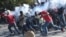 A tear gas canister, fired by the police, hits protesters during the clashes in front of the National Palace, in the center of Haitian capital Port-au-Prince, Feb. 13, 2019, on the sixth day of protests against Haitian President Jovenel Moise.
