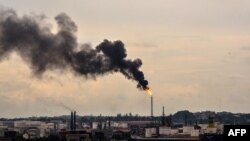 FILE - Black smoke billows from the chimney of an oil refinery in Havana, Cuba, June 5, 2017.