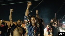 Protesters raise their fists during a demonstration against the shooting of Jacob Blake in Kenosha, Wis., on Aug. 26, 2020.