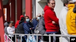 FILE - People wait in line for help with unemployment benefits in Las Vegas, Nevada, March 17, 2020.