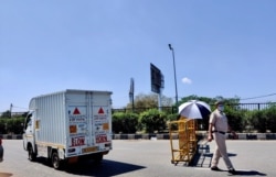 A police officer mans a checkpoint enforcing New Delhi's coronavirus lockdown. (Anjana Pasricha/VOA)