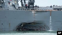 FILE - damage is visible as the guided-missile destroyer USS John S. McCain steers towards Changi naval base in Singapore following a collision with the merchant vessel Alnic MC. 