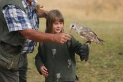 A child interacts with a bird at the Kuimba Shiri bird sanctuary near Harare, Zimbabwe, June 17, 2020.