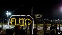 With the White House in the background, a line of police forms behind a fence in Lafayette Park as demonstrators gather to protest the death of George Floyd, June 2, 2020, near the White House in Washington.
