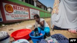 A woman washes clothes at a camp for people who lost their homes during the Aug. 14 earthquake, in Les Cayes, Haiti, Aug. 23, 2021.