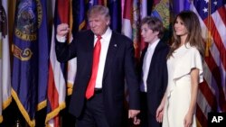 President-elect Donald Trump pumps his fist after giving his acceptance speech as his wife Melania Trump, right, and their son Barron Trump follow him during his election night rally in New York, Nov. 9, 2016.