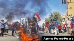 Para warga Sudan turun ke jalan dan membakar ban dalam aksi protes menentang kudeta militer yang terjadi di negara tersebut. Aksi tersebut berlangsung di Khartoum, pada 9 Januari 2022. (Foto: AFP) 