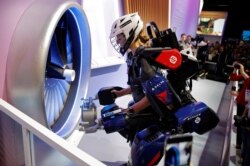 FILE - Tara Scranton demonstrates the Sarcos Robotics Guardian XO at the Delta Airlines booth during the CES tech show, Jan. 8, 2020, in Las Vegas. The full-body powered exoskeleton is designed to boost the user's strength and endurance.