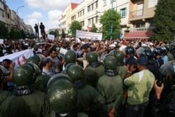FILE - Police face protesters pushing for democratic reforms during a rally organized by the country's "February 20" street movement in Casablanca, Morocco, July 3, 2011, in the follow-up to Morocco's "Arab Spring" protests.