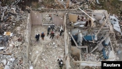 Equipos de rescate retiran escombros en el sitio donde al menos 52 personas murieron por un ataque con misiles rusos en la aldea de Hroza, en la región de Kharkiv, el 6 de octubre. 2023.