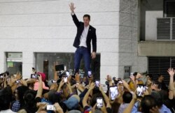 Opposition leader Juan Guaido waves to supporters during a rally at Bolivar Plaza, in Chacao, Venezuela, Feb. 11, 2020.