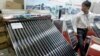 FILE - A solar water heater, left, and a solar panel are seen at Entech Hanoi, an international trade fair on energy efficiency and the environment, at the Giang Vo Exhibition Center in Hanoi, Vietnam.
