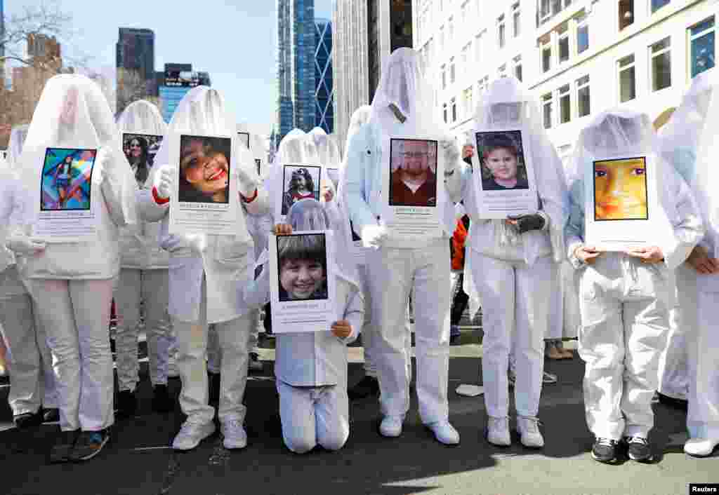 Protesters hold photos of school shooting victims during a "March For Our Lives" demonstration in New York City, 2018.