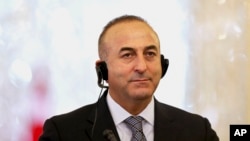 Turkish Foreign Minister Mevlut Cavusoglu listens to translation of a question in a joint press conference with his Iranian counterpart Mohammad Javad Zarif in Tehran, Iran, Dec. 17, 2014.