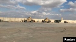 FILE - Military vehicles of U.S. soldiers are seen at the al-Asad air base in Anbar province, Iraq, Jan. 13, 2020. U.S. forces in Iraq and Syria have been attacked with drones or rockets at least 27 times in recent days, a Pentagon spokesman said.