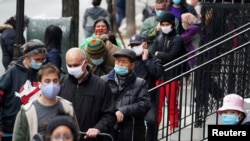 FILE - People wait in line at the St. Clements Food Pantry for food during the coronavirus pandemic in the Manhattan borough of New York City, New York, Dec. 11, 2020. 