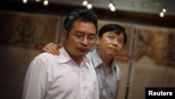 Chinese dissidents Yu Dongyue (L) and Lu Decheng walk through the Laogai Museum, which documents China's forced labor camp system, in Washington, June 2, 2009.