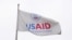 FILE - A USAID flag flutters outside as the USAID building sits closed to employees after a memo was issued freezing funding, in Washington, Feb. 3, 2025.