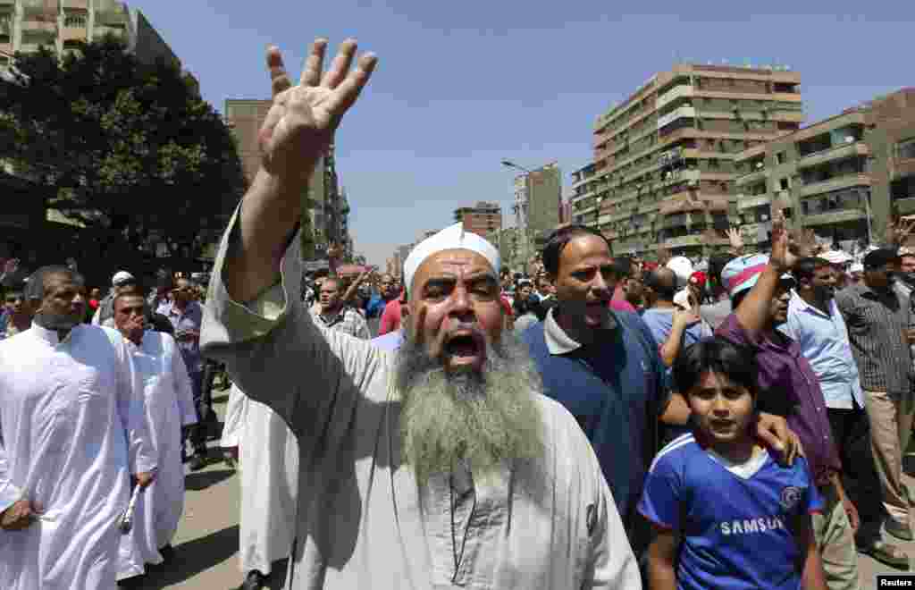 Supporters of the Muslim Brotherhood and ousted Egyptian President Mohamed Morsi shout slogans against the military and the interior ministry as they gesture "Rabaa," Cairo, August 23, 2013. 