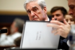 Former special counsel Robert Mueller checks pages in the report as he testifies before the House Judiciary Committee hearing on his report on Russian election interference, on Capitol Hill, Wednesday, July 24, 2019 in Washington.