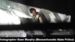 FILE - An injured Dzhokhar Tsarnaev is seen emerging from the boat in which he was hiding from police.