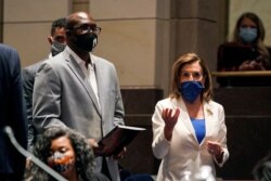 FILE - Philonise Floyd, a brother of George Floyd, and House Speaker Nancy Pelosi of Calif., arrive for a House Judiciary Committee hearing on proposed changes to police practices and accountability on Capitol Hill, June 10, 2020, in Washington.
