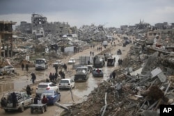 FILE - Mobil dan pejalan kaki bergerak di sepanjang jalan di tengah kerusakan yang disebabkan oleh serangan militer Israel terhadap Hamas di kamp pengungsi Jabaliya, Kota Gaza, 7 Februari 2025. (Jehad Alshrafi, arsip/AP)