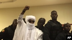 L'ancien chef de l'Etat tchadien Hissène Habré lève la main lors d'une audience dans un tribunal à Dakar, au Sénégal, le 30 mai 2016. (AP Photo/Carley Petesch)