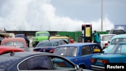 Waves splash onto the seafront Malecon as cars line up to have their tanks filled with gasoline in Havana, Cuba, April 7, 2017. 